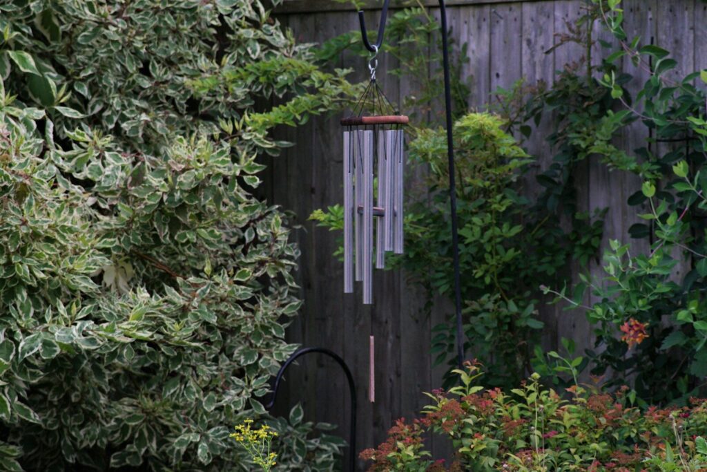 a wooden fence with a wheel and plants around it