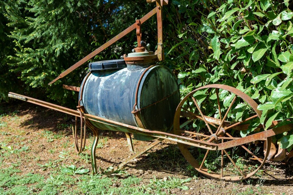 Rusty antique farm equipment with a water tank